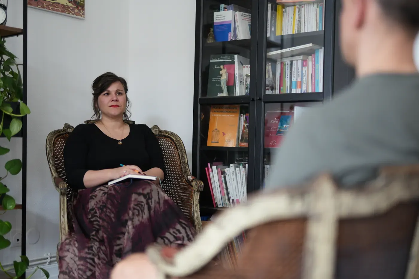 Julie Eggenspieler à l'écoute d'une personne assise face à elle, au cabinet
